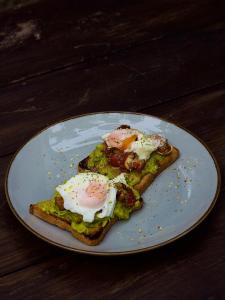 a plate with two eggs on top of toast at Cozy Space - Madiha in Matara