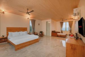 a bedroom with a bed and a couch and a television at Hotel Sarai Bharatgarh in Nohan