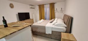 a bedroom with a bed and a desk with a television at Apartmani Luan in Vis