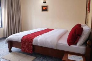 a bedroom with a bed with a red and white blanket at COLIBRI VILLA City Center in Gisenyi