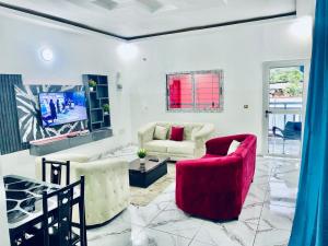 a living room with two chairs and a tv at Residence Gold in Man