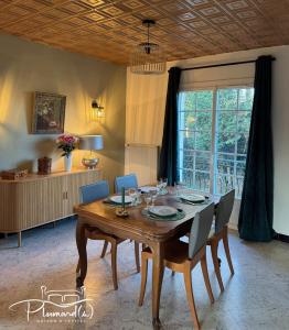 a dining room with a wooden table and chairs at Plumards, maison d'invités proche Abbaye in Argoules