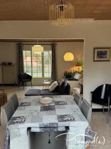 a living room with a table and a couch at Plumards, maison d'invités proche Abbaye in Argoules