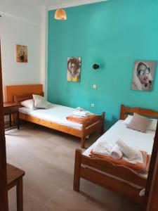 two beds in a room with blue walls at Flowers studios in Benitses