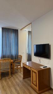 ein Hotelzimmer mit Schreibtisch und Fernseher an der Wand in der Unterkunft Willkommen24 in Pfullingen