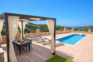 a patio with a table and chairs and a swimming pool at Natural view villa with private pool in Skouloúfia