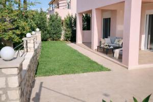 a backyard with a lawn and a fence at Natural view villa with private pool in Skouloúfia +17 photos