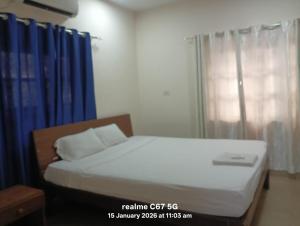 ein Bett in einem Zimmer mit blauen Vorhängen in der Unterkunft Hotel HCG in Santa Cruz