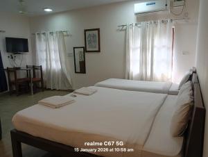 ein Hotelzimmer mit zwei Betten und einem Fernseher in der Unterkunft Hotel HCG in Santa Cruz