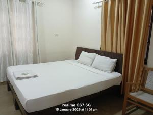ein Schlafzimmer mit einem Bett mit weißen Laken und einem Stuhl in der Unterkunft Hotel HCG in Santa Cruz