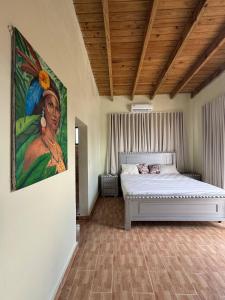 a bedroom with a bed with a painting on the wall at Las Indgenas 6BR Pool Jacuzzi Gazebo in Imbert +95 photos