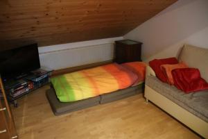a small bedroom with a bed and a tv at Christina's Bergblick in Oberammergau