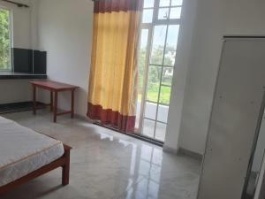 a bedroom with a bed and a large window at A & S residences in Pannipitiya