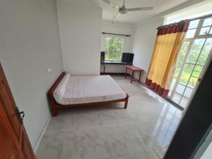 a bedroom with a bed in the corner of a room at A & S residences in Pannipitiya