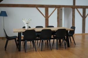 a wooden table with black chairs around it at The nestie in Walhain-Saint-Paul