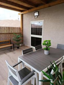 ein Holztisch und Stühle auf einer Terrasse in der Unterkunft אלת המדברGoddess of the desert in Beʼer Ora