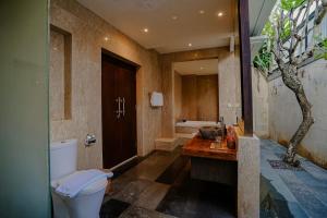 a bathroom with a toilet and a bath tub at Villa Campania in Blahbatu +8 photos