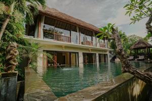 a house with a swimming pool in front of it at Villa Campania in Blahbatu