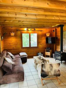 a large living room with a couch and a tv at La cabane du Cerf in Stavelot