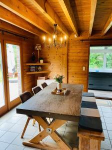 a dining room with a large wooden table and chairs at La cabane du Cerf in Stavelot +25 photos