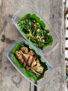 two plastic containers filled with food on a table at Arkana Huis in Perawas