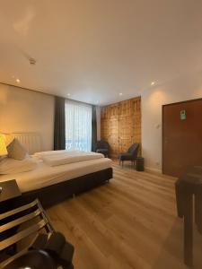 a bedroom with a bed and a desk and a chair at Hotel Berghof in Berg im Drautal +95 photos