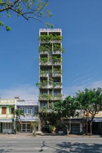 a tall apartment building with plants on it at The Shine Hotel & Apartment in Danang