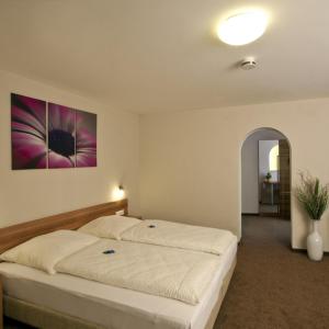 a bedroom with a large bed with a painting on the wall at Hotel Sielminger Hof in Filderstadt