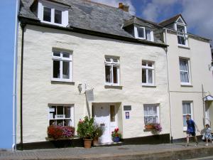 a white house with flowers in front of it at Cyntwell Guest Accommodation in Padstow