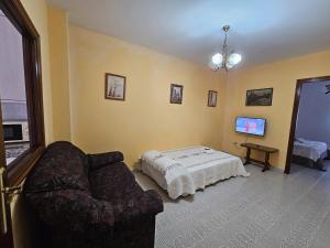 a living room with a couch and a bed at Pensión Lubina in Bueu