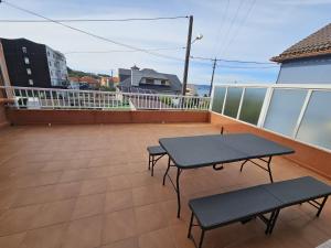 a balcony with a table and two benches on it at Pensión Lubina in Bueu