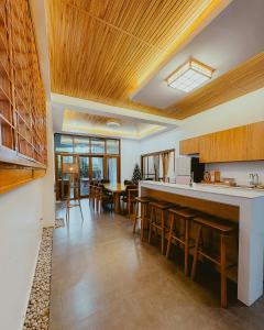 a kitchen with wooden ceilings and a bar with wooden stools at Villa Kaiyo La Union in Bacnotan