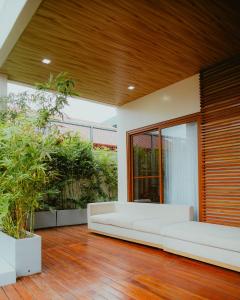 a living room with a white couch on a wooden floor at Villa Kaiyo La Union in Bacnotan
