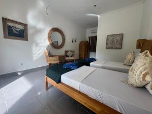 a bedroom with two beds and a mirror at Blue EmOcean Dive Eco lodge in Moyo Island