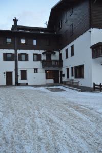 a large white building with snow on the ground at Casa Alpina Place in Isolaccia