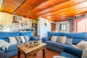 a living room with blue couches and a table at Cubo's Casa Mi Recreo High Privacy in Yunquera