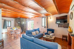 a living room with a blue couch and a table at Cubo's Casa Mi Recreo High Privacy in Yunquera