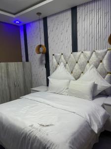 a large bed with white sheets and pillows at M & J Executive Suites in Johannesburg +3 photos