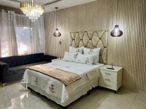 a bedroom with a large bed and a couch at M & J Executive Suites in Johannesburg