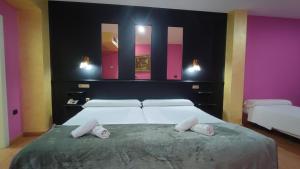 a bedroom with a large bed with two pillows on it at Hotel Aro'S in Casas Ibáñez