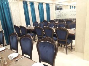a dining room with a long table and chairs at Hotel Regency International in Jamnagar