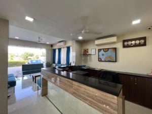 a lobby with a bar with chairs and a couch at Hotel Regency International in Jamnagar