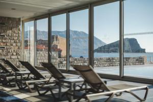 a row of chairs sitting in a room with windows at Avala Resort & Villas in Budva