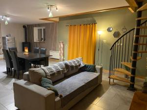 a living room with a couch and a dining room at Gîte cosy 6 personnes, avec jardin en Normandie, proche des plages du débarquement et du Mont Saint-Michel in La Luzerne
