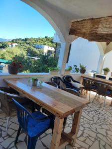 a wooden table and chairs on a patio at Robinson Dora in Putniković