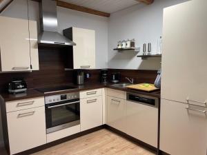 a kitchen with white cabinets and a stove top oven at Ferienhaus Alex - Wohnung im DG in Malliß
