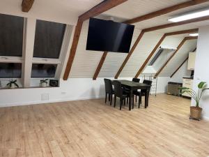a dining room with a table and chairs and a flat screen tv at Ferienhaus Alex - Wohnung im DG in Malliß +5 photos
