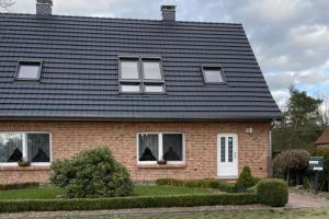a house with a black roof with chickens in the windows at Ferienhaus Alex - Wohnung im DG in Malliß