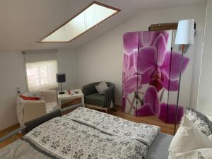 a bedroom with a purple flower on the wall at Seelenbaumlerin in Schliersee