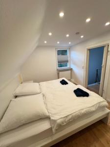 a bedroom with a white bed with two towels on it at Ferienhaus mit Trifelsblick in Annweiler am Trifels +31 photos